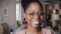 Pretty young African American happy female leader in glasses smiling at camera in modern office co-working background 4K Royalty Free Stock Photo