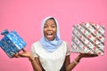 pretty young african woman holding gift boxes smiling and feeling excited Royalty Free Stock Photo