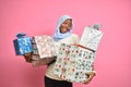 pretty young african woman holding a lot of gift boxes feeling happy and excited Royalty Free Stock Photo