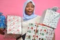 pretty young african woman holding plenty gift boxes smiling and feeling excited and surprised Royalty Free Stock Photo