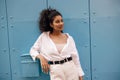 Pretty young african woman looking into distance leaned on mailbox gate leading to courtyard. Royalty Free Stock Photo