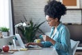Pretty young afro woman shopping online with credit card with laptop while working on office at home Royalty Free Stock Photo