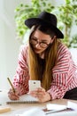 Pretty young architect woman working on a blueprints while using her mobile phone in the office. Royalty Free Stock Photo