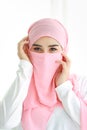 Pretty young asian Arabian woman wearing pink hijab confident in studio. white background portrait with beautiful muslim