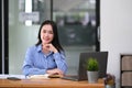 Pretty young Asian businesswoman sitting in office using laptop computer. Royalty Free Stock Photo