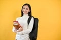 A pretty young Asian female college student with her backpack holding her books. Education concept Royalty Free Stock Photo