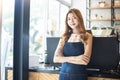 Pretty young asian waitress standing arms crossed in cafeteria.Coffee Business owner Concept. barista in apron smiling at camera