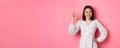 Pretty young asian woman in dress showing okay sign, praising and showing approval, looking satisfied, standing against Royalty Free Stock Photo