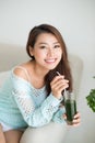 Pretty young asian woman drinking green fresh vegetable juice or Royalty Free Stock Photo