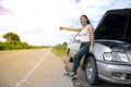 Pretty young Asian woman with hand up calling passing car. Royalty Free Stock Photo