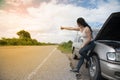 Pretty young Asian woman with hand up calling passing car. Royalty Free Stock Photo