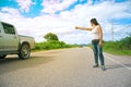 Pretty young Asian woman with hand up calling passing car. Royalty Free Stock Photo