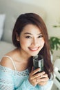 Pretty young asian woman holding green fresh vegetable juice or Royalty Free Stock Photo