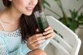 Pretty young asian woman holding green fresh vegetable juice or Royalty Free Stock Photo