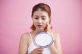 Pretty young asian woman holding a mirror, touch and worrying ab Royalty Free Stock Photo