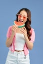 Pretty young Asian woman with juicy watermelon on color blue background