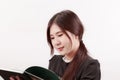 Pretty young Asian woman reading a book with considerate and thoughtful posture. Royalty Free Stock Photo