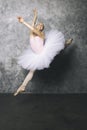 Pretty young ballerina dancer dancing classical ballet against rustic wall Royalty Free Stock Photo