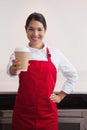 Pretty young barista offering cup of coffee to go Royalty Free Stock Photo