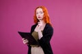 Pretty young beautiful woman standing, writing, take notes, holding textbook notebook organizer in hand and pen Royalty Free Stock Photo