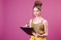 Pretty young beautiful woman standing, writing, take notes, holding textbook notebook organizer in hand and pen Royalty Free Stock Photo