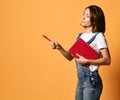 Pretty young beautiful woman standing, writing, take notes, holding textbook notebook organizer in hand and pen Royalty Free Stock Photo