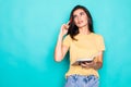 Pretty young beautiful woman standing, writing, take notes, holding textbook notebook organizer in hand and pen on turquoise Royalty Free Stock Photo