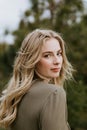 Pretty Young Beauty Woman Model with Gorgeous Long Blond Hair Blowing in the Wind Smiling for Portrait Shots Outside at the Park Royalty Free Stock Photo