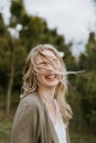 Pretty Young Beauty Woman Model with Gorgeous Long Blond Hair Blowing in the Wind Smiling for Portrait Shots Outside at the Park Royalty Free Stock Photo