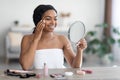 Pretty young black woman applying make up and smiling Royalty Free Stock Photo