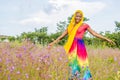 pretty young black woman having fun alone playing with flowers in a field