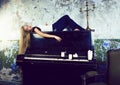 pretty young blond real girl at piano in old-style rusted interi