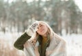 Pretty young blond woman, dressed warmly, with a scarf and mittens. Beautiful girl enjoying in the snow Royalty Free Stock Photo