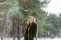 Pretty young blond woman, dressed warmly, with a scarf and mittens. Beautiful girl enjoying in the snow Royalty Free Stock Photo