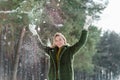 Pretty young blond woman, dressed warmly, with a scarf and mittens. Beautiful girl enjoying in the snow Royalty Free Stock Photo