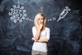 Pretty young blonde girl makes a choice between coronavirus vaccination on a background of dark chalk board. Vaccination and virus