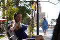 Pretty young blonde Latina woman with a ponytail in her hair is resting sitting on a bench in the city. The woman is smiling and Royalty Free Stock Photo