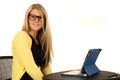 Pretty young blonde wearing glasses sitting at desk Royalty Free Stock Photo