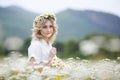 Pretty young blonde woman with camomiles in white blooming field. girl in camomile wreath Royalty Free Stock Photo