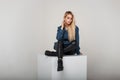 Pretty young blonde woman in fashion denim clothes in leather