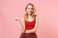 Pretty young blonde woman girl in red sexy clothes posing isolated on pastel pink wall background studio portrait Royalty Free Stock Photo