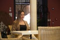 Pretty young blonde woman sitting in a wicker armchair in the inner courtyard of a hotel. The woman reads a book. Concept book day Royalty Free Stock Photo