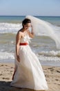 Pretty young bride walking on a sea beach Royalty Free Stock Photo