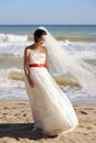 Pretty young bride walking on a sea beach Royalty Free Stock Photo