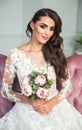 Pretty young bride in white wedding dress holding a bridal bouquet
