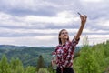 Pretty young female tourist makes selfie in Mountain. Woman traveler taking selfie in mountains, travel lifestyle Royalty Free Stock Photo