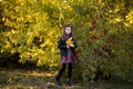 Pretty brunette girl in leather jacket, boots and flower dress posing in the autumn park. Copy space Royalty Free Stock Photo