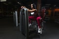 Pretty young brunette girl is relaxing in leg`s training apparatus in the gym Royalty Free Stock Photo