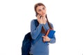 Pretty young brunette student girl with blue backpack talking phone isolated on white background Royalty Free Stock Photo