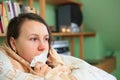 Pretty young brunette woman blowing her nose by white handkerchief, illness concept, sore throat Royalty Free Stock Photo